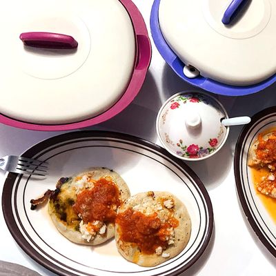 pupusas on table with cabbage and tomato sauce