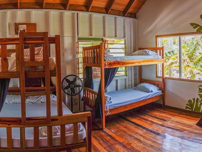 two bunk beds in wooden house with fan