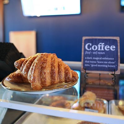 croissant on plate by coffee sign