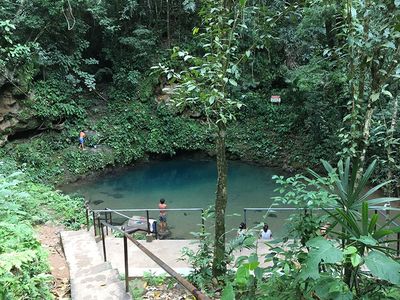 small blue swimming hole with swimmers around