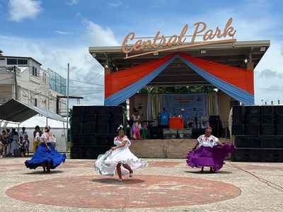 women dancing in maya dresses at park square