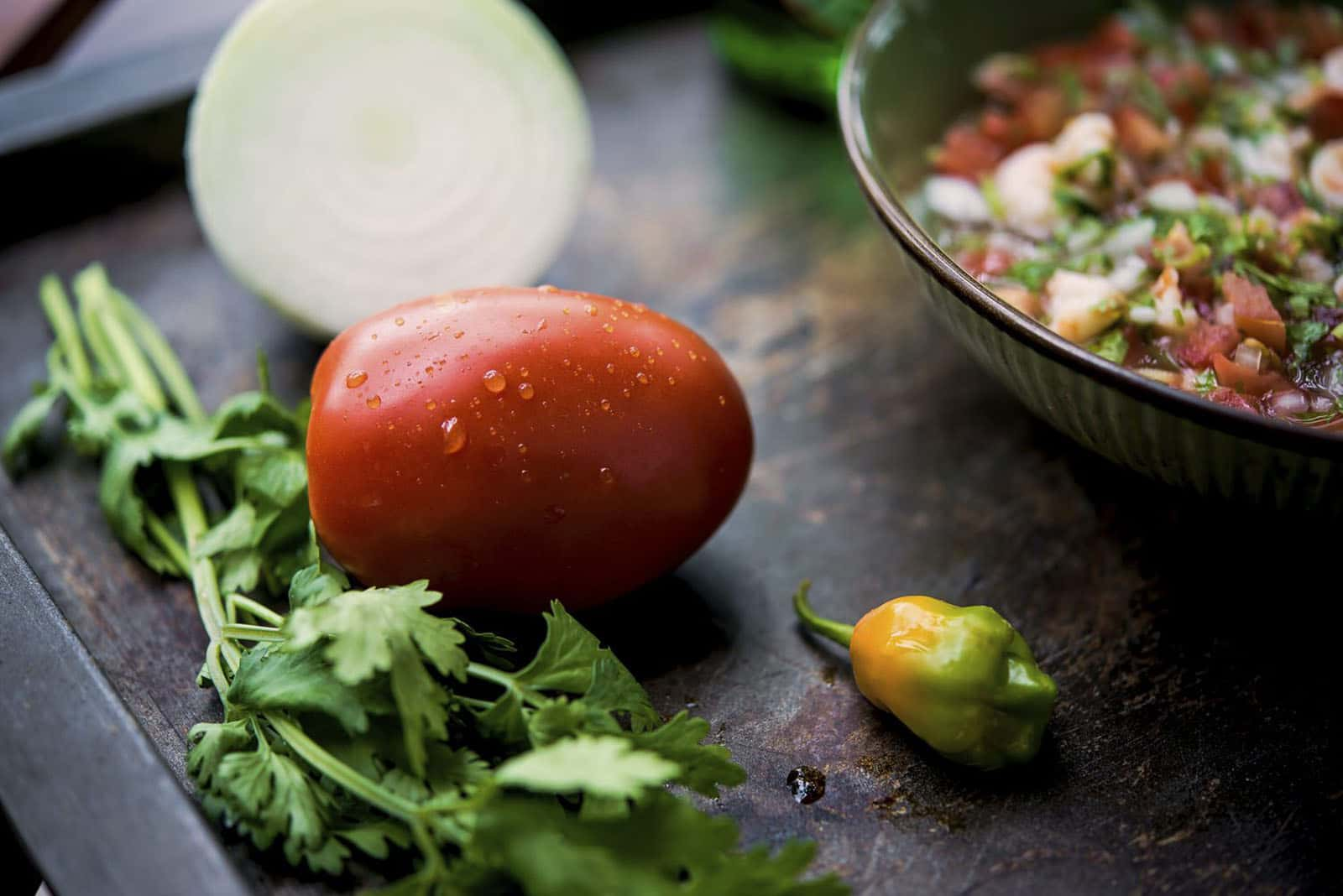 tomato and cilantro in front of ceviche plate