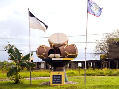 drum statue between two flags