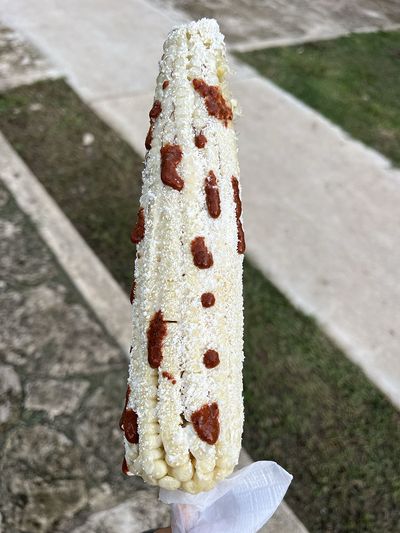 corn with cheese and pepper on a cob