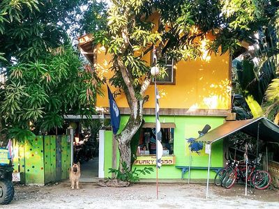 two story buliding with trees around and dog at the door