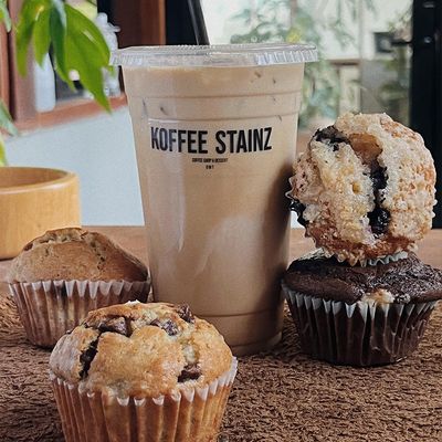 branded coffee cup with cupcakes surrounding it