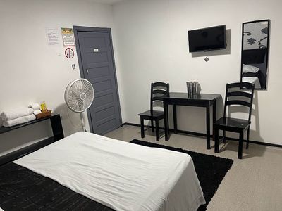 bed with fan and small table and two chairs