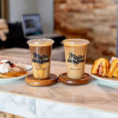 branded coffee cups with breakfast dishes surrounding it