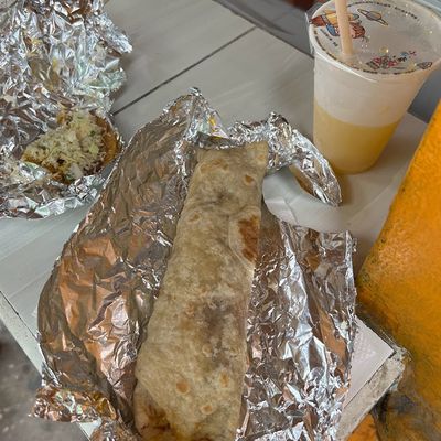 burrito wrapped by foil with orange drink