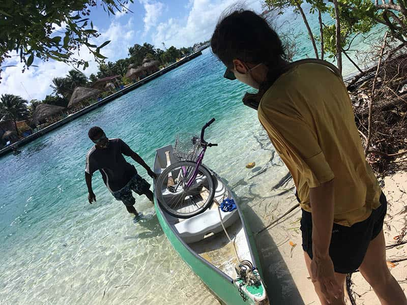 man loading bike on top of canoe to transport