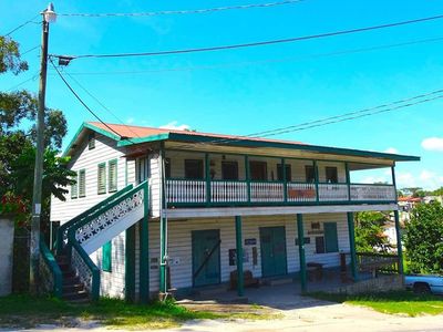 old white and green house on a steep hill