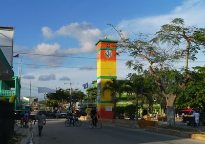 colorful town clock surrounded by trees and buildings