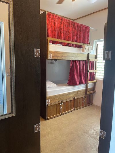 tidy bunk bed with red privacy curtains