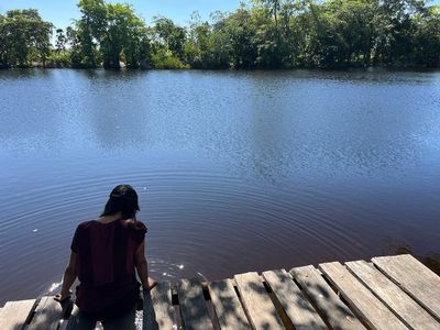 girl sitting in dock by village river